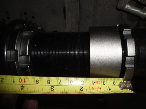 1995 Ford Taurus - A tape measure is used to show the diameter of a coilover suspension component.