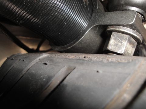 1995 Ford Taurus - A close-up view shows a black coilover suspension component positioned above a tire with visible wear.