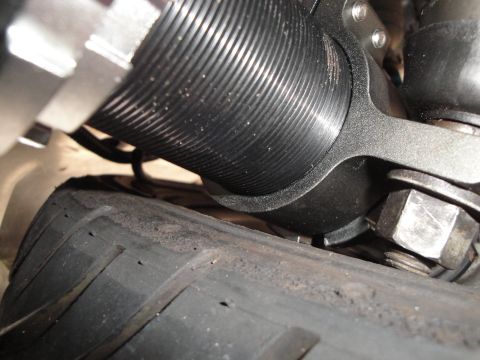 1995 Ford Taurus - A close-up view of a vehicle's coilover suspension part is shown above a tire.