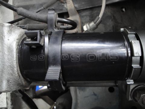 1995 Ford Taurus - A close-up view of a black coilover shock absorber, identified by the text 'OS OHS'.