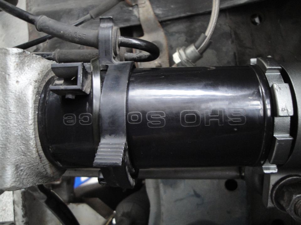 Black coilover shock absorber with 'OS OHS' text and a black zip tie