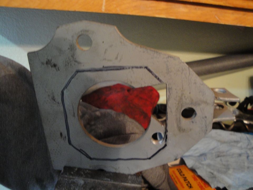 Metal bracket with a marked outline and a circular cutout, a red cloth is visible inside the cutout