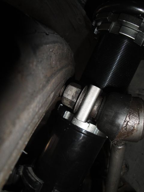 1995 Ford Taurus - Close-up view of a black coilover suspension component, likely an aftermarket part, situated near a tire.