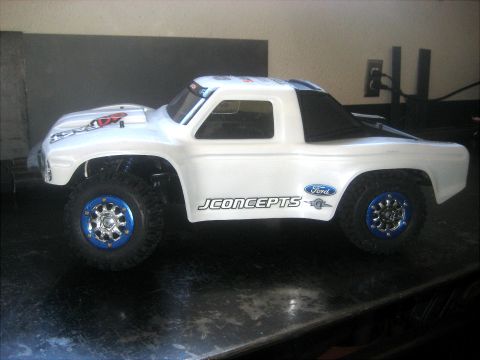 1996 Ford Bronco - This RC truck features a white body with blue accents on the wheels and JConcepts branding.