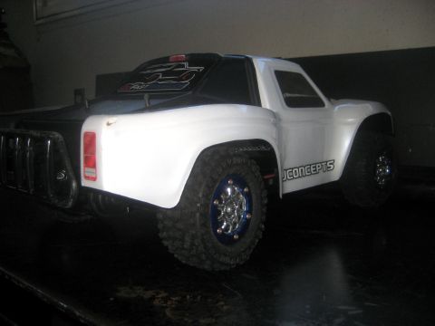 1996 Ford Bronco - This RC truck features a white cab and black bed, with distinctive blue-rimmed wheels.