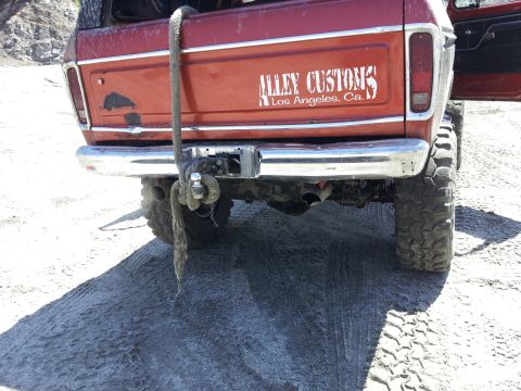 1978 Ford Bronco - Rear view of a red 1978 Ford Bronco showing its chrome bumper, tow hitch, and a custom decal.