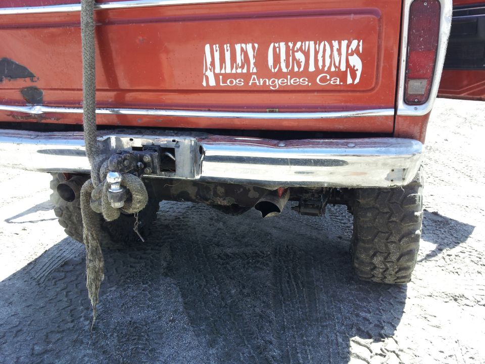 Orange 1978 Ford Bronco rear with "Alley Customs Los Angeles, Ca." decal and tow hitch
