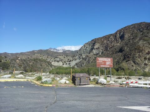 1978 Ford Bronco - A scenic view of a mountain range under a clear blue sky, a large informational sign and a dumpster in the foreground.