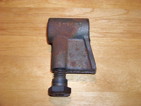 1995 Mercury Grand Marquis - A close-up of a rusty metal component with a bolt attached, resting on a wooden surface.