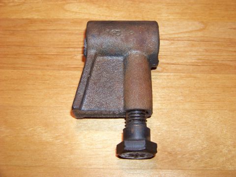 1995 Mercury Grand Marquis - A close-up view of a cast metal part with a bolt, set against a wood-grain background.