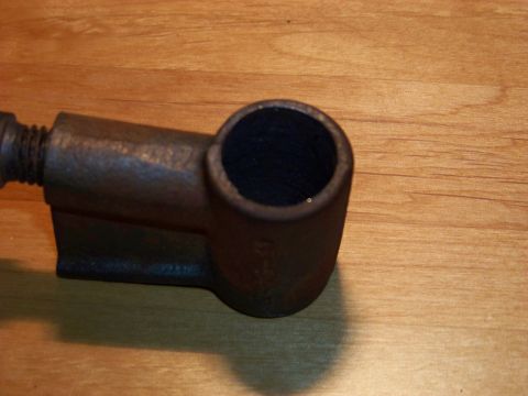 1995 Mercury Grand Marquis - A close-up view of a single, aged metal component resting on a wood-grain background.
