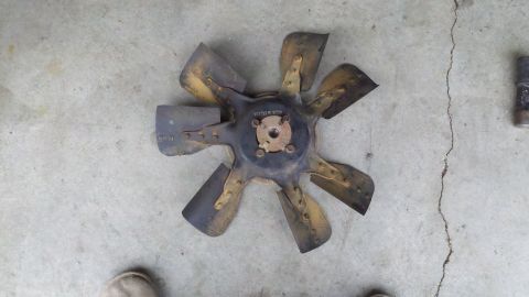 1978 Ford Bronco - A radiator fan blade is shown from above, lying on a cracked concrete floor.