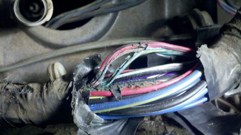 1978 Ford Bronco - Close-up of a damaged vehicle wiring harness with multiple wires exposed and corroded.