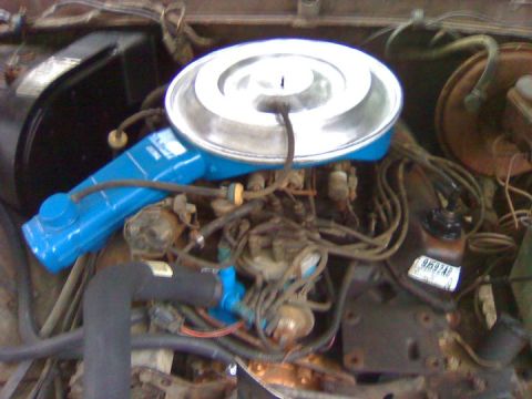 1979 Ford Bronco - Close-up view of an engine bay, showing various components and wiring. A sticker with a code is visible on a part.