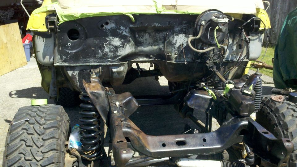 1978 Ford Bronco frame and suspension during restoration. Front tire and coil spring visible