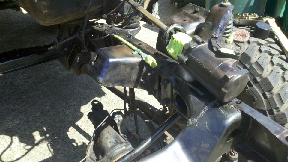 close-up of vehicle frame, suspension parts, and tire tread