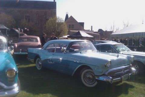 1991 Ford LTD Crown Victoria - A two-tone blue 1957 Buick Century coupe is parked on the grass at an outdoor car show.