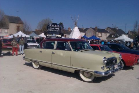 1991 Ford LTD Crown Victoria - A vintage Nash Ambassador sedan is displayed at an outdoor event with other vehicles and attendees.