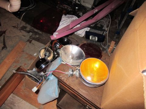 1991 Ford LTD Crown Victoria - A collection of various automotive lighting components are scattered in a cluttered environment.
