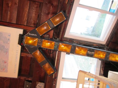 1991 Ford LTD Crown Victoria - Arrow-shaped light bar with amber lights, mounted indoors near a window.