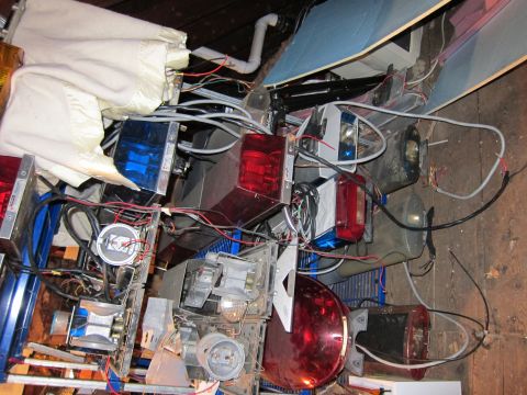 1991 Ford LTD Crown Victoria - Disassembled components of an emergency vehicle light bar are piled together, showing various lenses and electrical wiring.