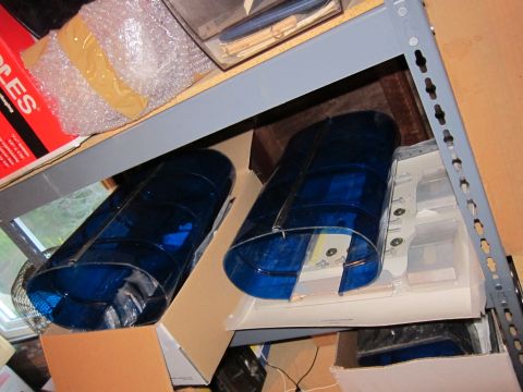 1991 Ford LTD Crown Victoria - Two blue plastic covers are stored on a shelf with other items.