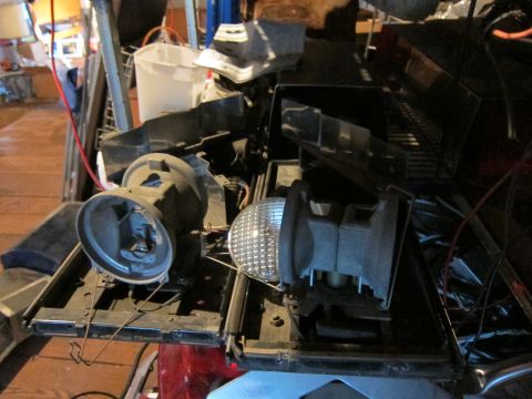 1991 Ford LTD Crown Victoria - Disassembled car parts, including headlights and grille components, are piled together.