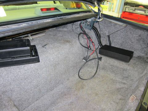 1991 Ford LTD Crown Victoria - The interior of a car trunk shows aftermarket audio equipment and wiring, with a glimpse of the taillight assembly.