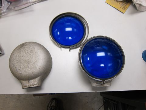 1991 Ford LTD Crown Victoria - Two blue automotive lighting lenses and a silver dome-shaped part are laid out on a white surface.