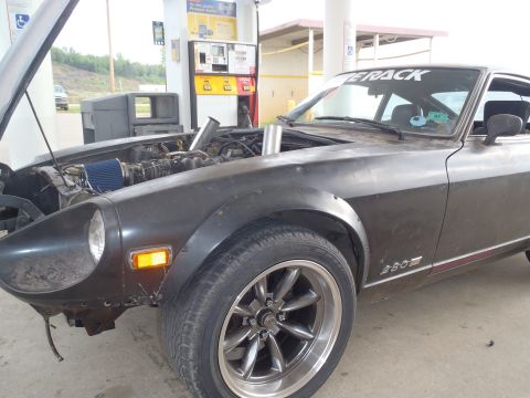 1978 Nissan 300ZX - A 1978 Nissan 300ZX is seen at a gas station with its hood up, revealing the engine and aftermarket wheels.