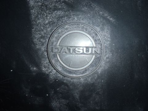1978 Nissan 300ZX - Close-up of a Datsun emblem, likely a wheel center cap or badge.