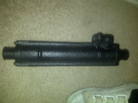 2000 Ford Crown Victoria - A close-up view of a black automotive part resting on a carpeted surface.