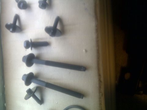 2000 Ford Crown Victoria - A collection of various bolts and fasteners are laid out on a surface, with a watermark at the bottom right.