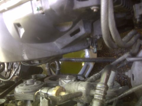 2000 Ford Crown Victoria - The engine bay of a 2000 Ford Crown Victoria shows a close-up of various components and a pool of yellow coolant.