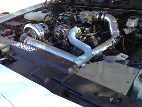 2004 Ford Crown Victoria - Custom supercharger system installed in an engine bay, showing polished metal components and piping.