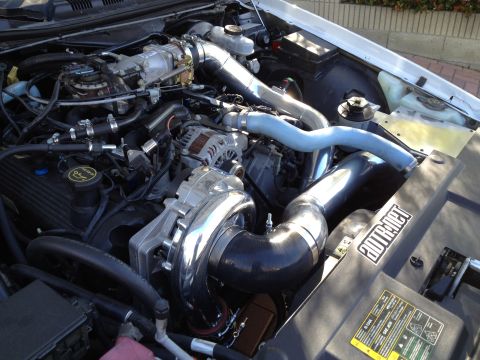 2004 Ford Crown Victoria - Close-up of a modified engine bay a prominent supercharger and intercooler piping.