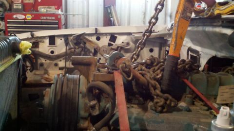 1993 Ford F-350 - An engine is being removed from a vehicle using an engine hoist and chains.