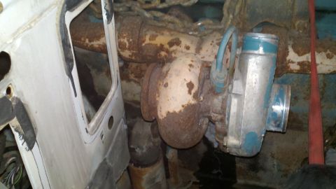 1993 Ford F-350 - The image shows a heavily rusted turbocharger and exhaust system, with a portion of a vehicle's interior visible.