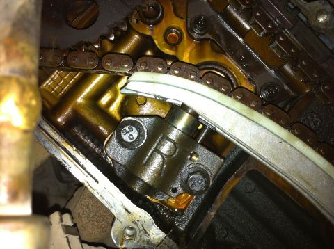 1998 Ford Crown Victoria - Close-up view of an engine's timing chain and tensioner mechanism, showing internal mechanical parts.