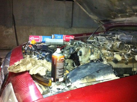 1998 Ford Crown Victoria - Engine bay of a vehicle with parts and tools laid out for work.