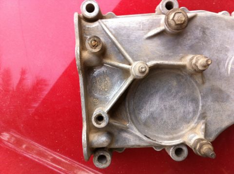 1998 Ford Crown Victoria - Close-up of a Ford timing cover, part number F6AE-6080-BC, against a red background.