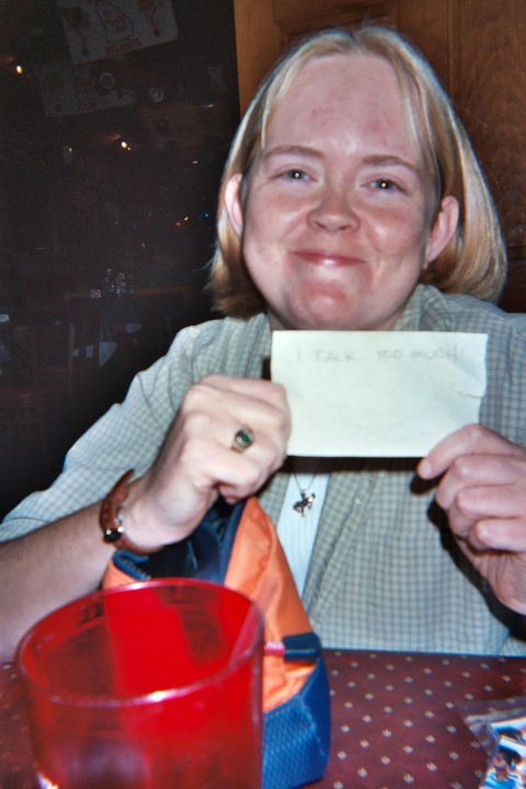 1988 Ford Bronco - A woman holds a note that reads "I TALK TOO MUCH" while sitting at a table with a red glass.