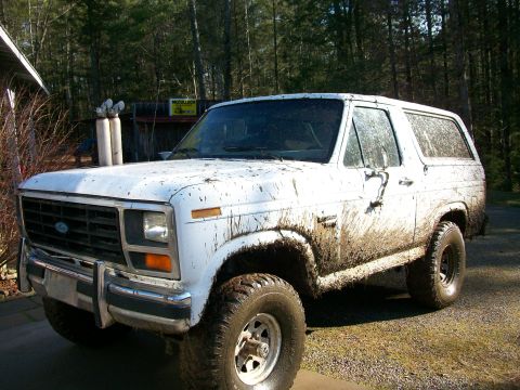 1985 Ford Bronco - This muddy 1985 Ford Bronco is shown from a 3/4 front angle.