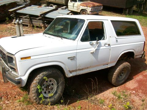 1985 Ford Bronco - White 1985 Ford Bronco with custom exhaust pipes visible on the hood.