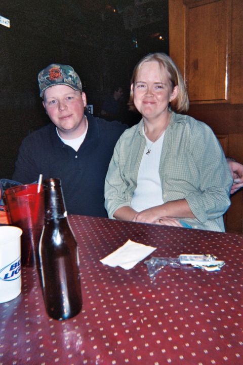 1988 Ford Bronco - Two people are seated at a table with drinks and a bottle in front of them.