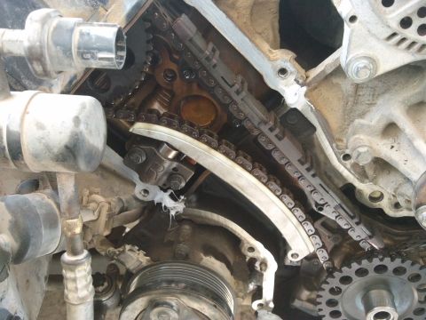 1998 Ford Crown Victoria - Close-up view of an engine's timing chain and tensioner mechanism, showing internal components.