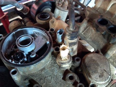 1993 Ford F-150 - This is a close-up view of an engine's oil filter housing, showing various components and some residual oil.