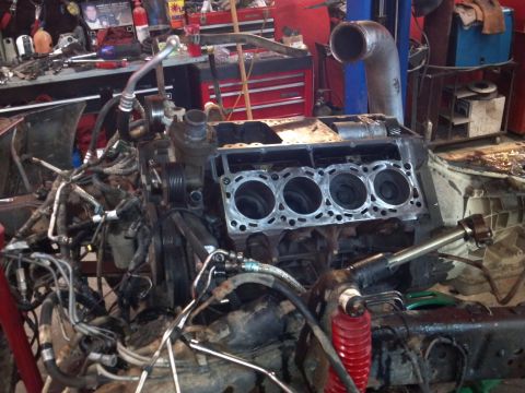 1993 Ford F-150 - Engine block with cylinders visible, undergoing repair or disassembly in a garage setting.