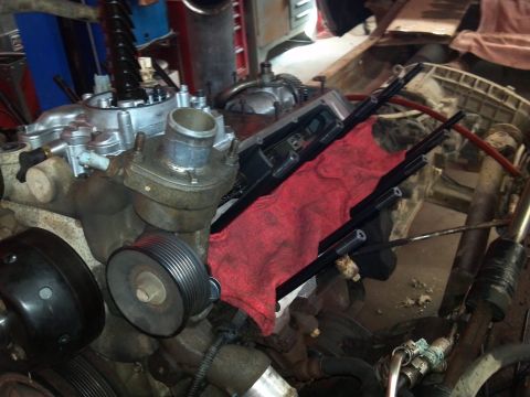 1993 Ford F-150 - Close-up view of engine parts, including spark plug wires and a red shop rag, during a repair or maintenance process.