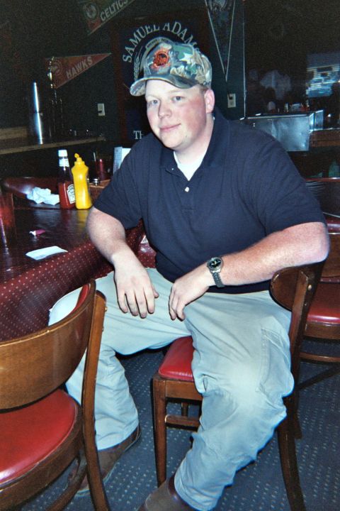 1988 Ford Bronco - Man sits at a table in a bar, with sports memorabilia and a beer sign in the background.